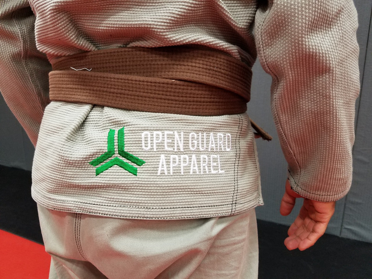 Bottom of the top Open Guard Apparel Circle Flow Gi in Tactical Sand & Emerald.