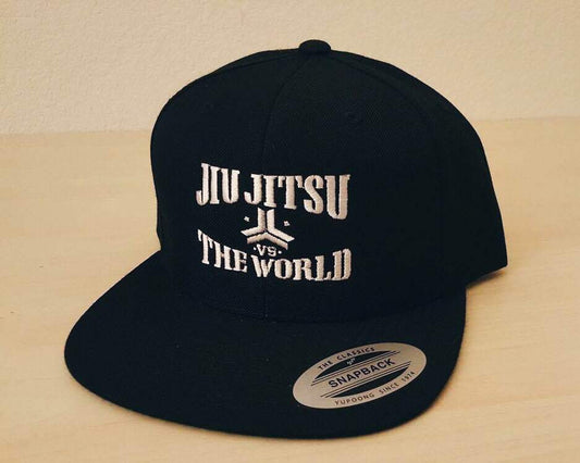 OGA Open Guard Apparel Jiu Jitsu vs The World Snapback hat.  Black hat with white embroidery.  Jiu Jitsu vs the world series from Open guard apparel. 