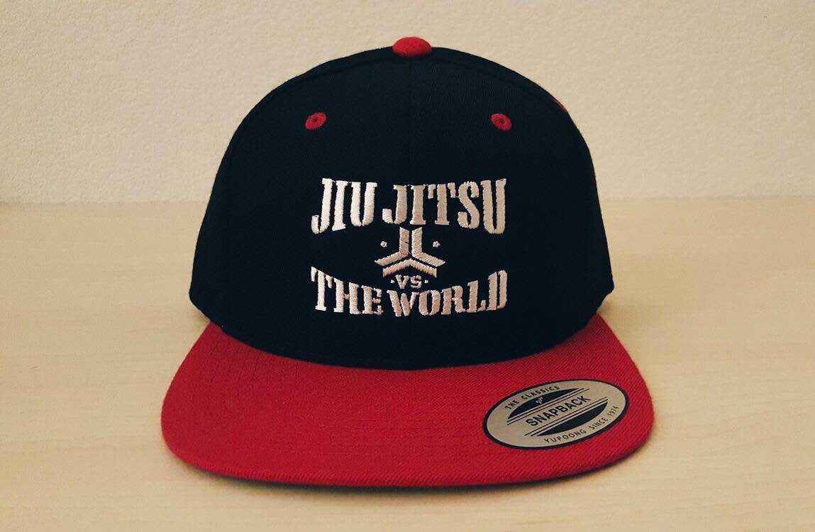 OGA Open Guard Apparel Jiu Jitsu vs The World Snapback hat.  Red black hat with white embroidery.  Jiu Jitsu vs the world series from Open guard apparel. 