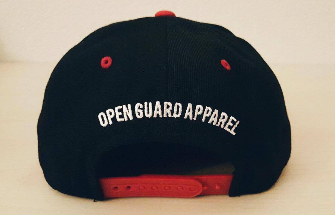 OGA Open Guard Apparel Jiu Jitsu vs The World Snapback hat.  Red black hat with white embroidery.  Jiu Jitsu vs the world series from Open guard apparel. 