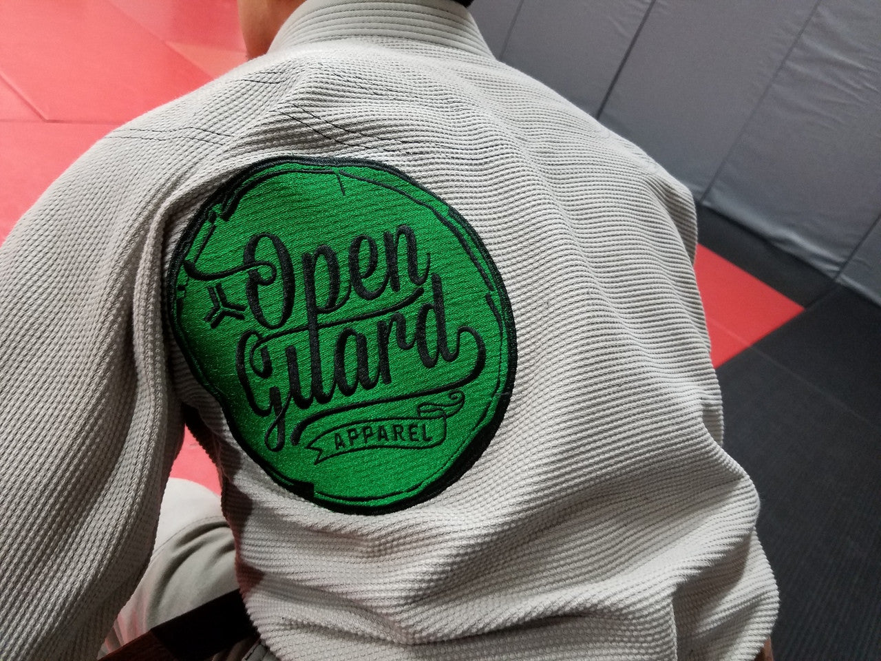 Embroidered patch on back of the Open Guard Apparel Circle Flow Gi in Tactical Sand & Emerald.  